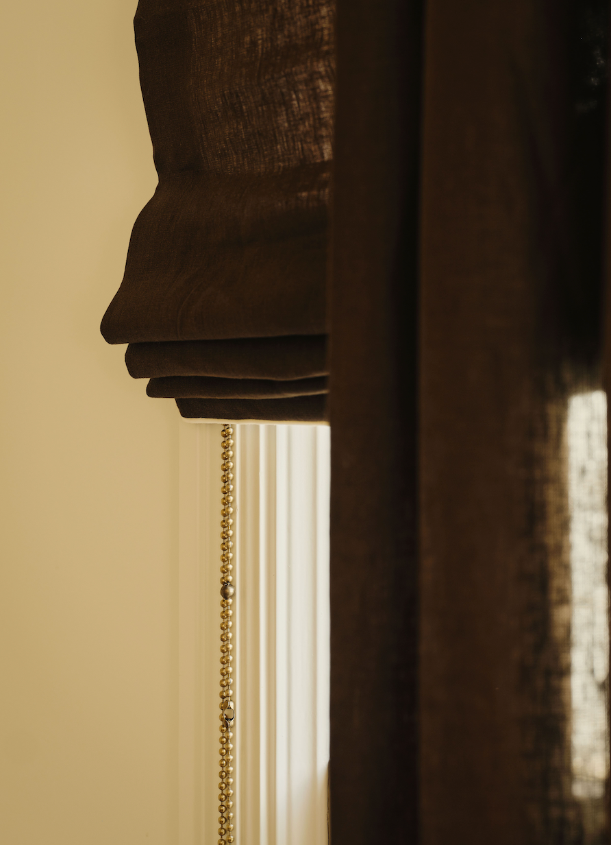 Soft cafe curtains over paired bathroom windows.