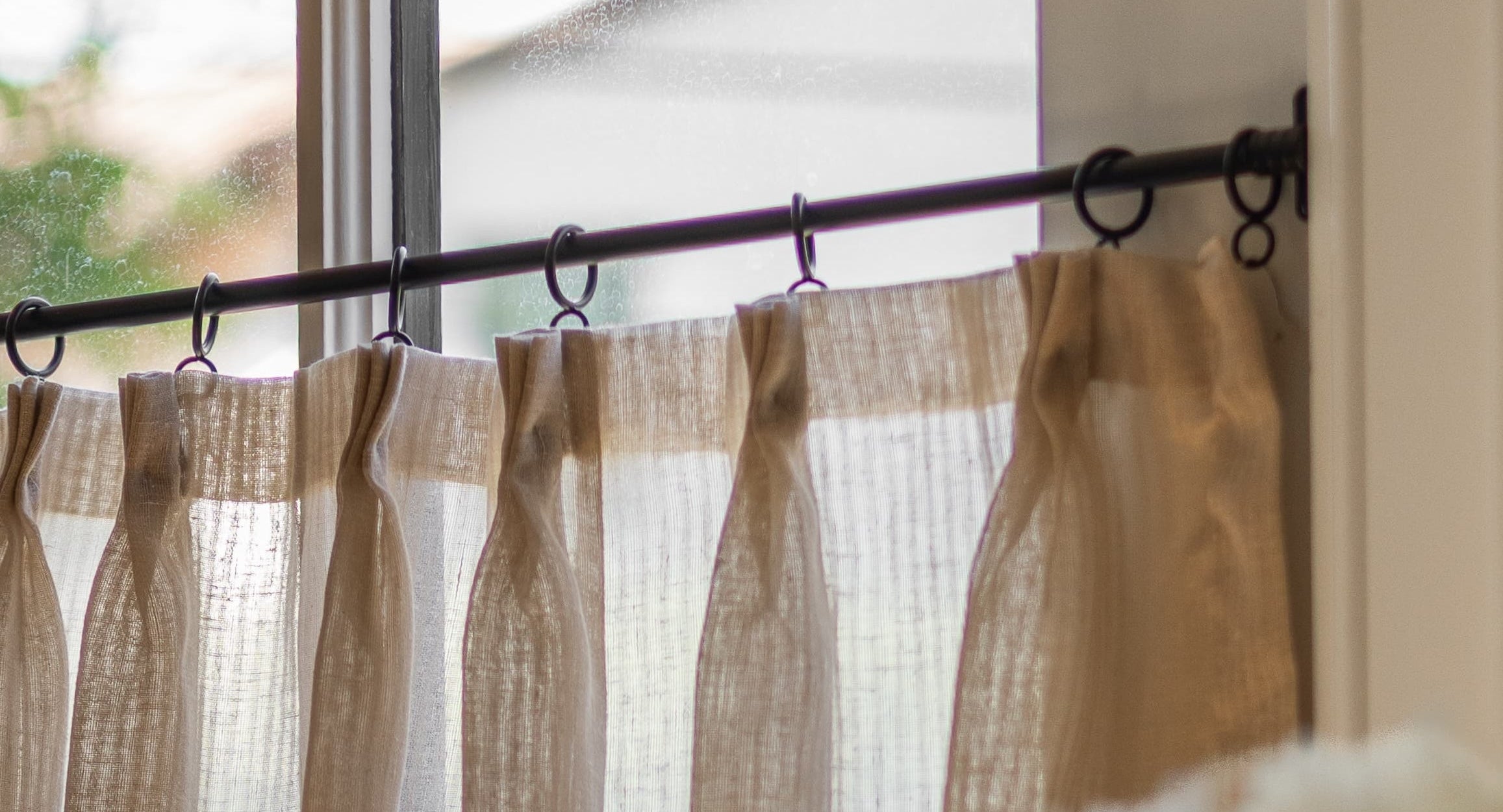 A kitchen window with custom Everhem café curtains.