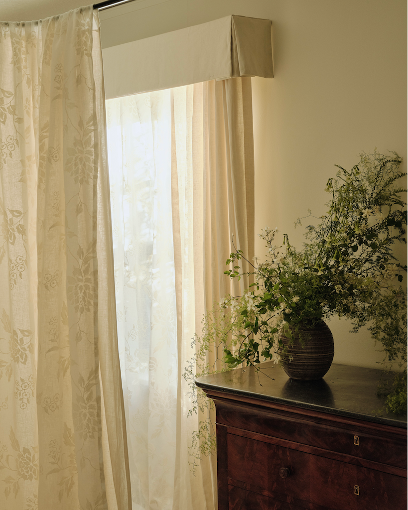 Layered sheer and solid drapery in a softly lit room.