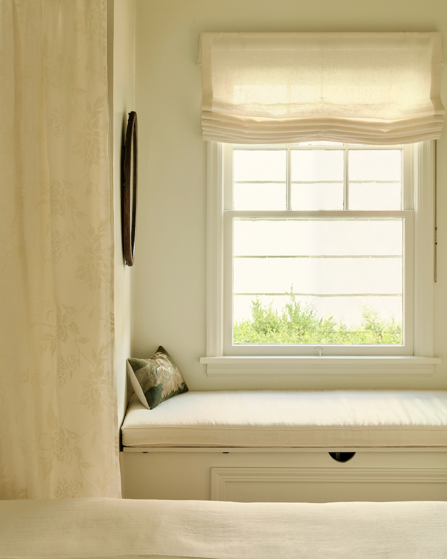 Sunlit kitchen sink with a soft roman shade.
