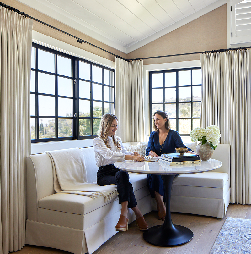 Designers consulting on custom drapery in a breakfast nook.