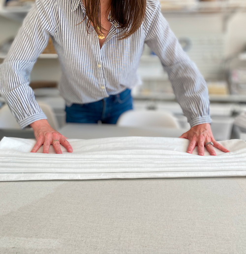 A craftsperson pressing custom drapery fabric.